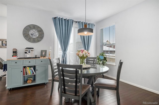 dining area with baseboards and dark wood-type flooring