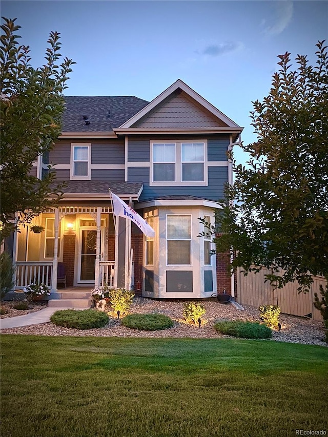 view of front facade featuring fence, a front lawn, and a porch