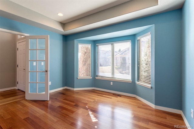 unfurnished room featuring visible vents, wood finished floors, and baseboards