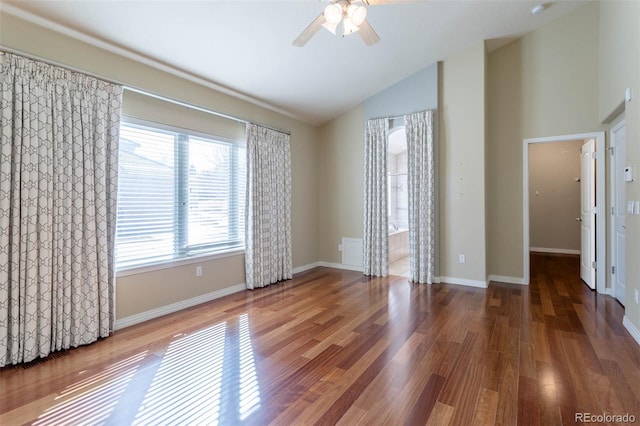 empty room featuring baseboards, wood finished floors, high vaulted ceiling, and ceiling fan