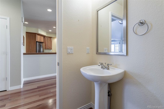 bathroom featuring recessed lighting, wood finished floors, and baseboards