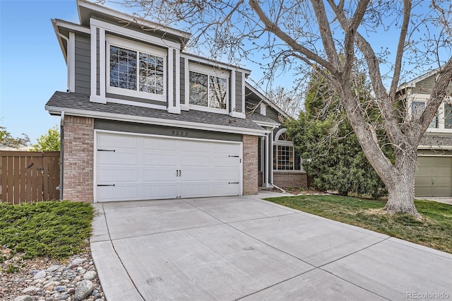 view of front of house featuring a garage, fence, roof with shingles, brick siding, and driveway