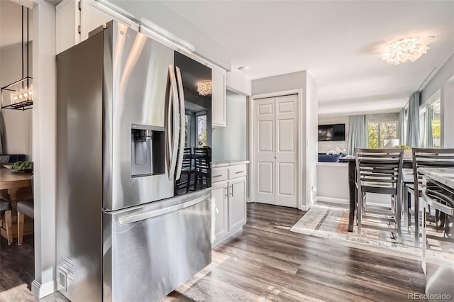 kitchen featuring stainless steel fridge with ice dispenser, light countertops, wood finished floors, and white cabinets