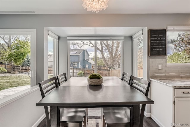 dining room with baseboards, dark wood-style floors, and a notable chandelier