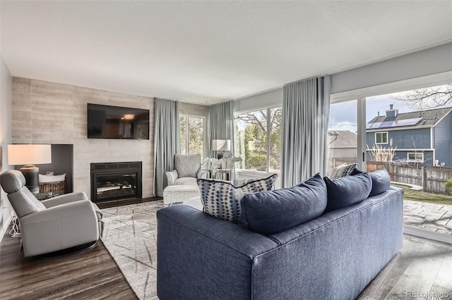 living area with wood finished floors and a tile fireplace