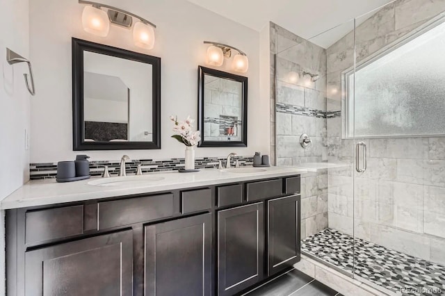 full bathroom with a sink, double vanity, and a stall shower