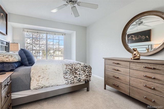 bedroom with light colored carpet, baseboards, and a ceiling fan