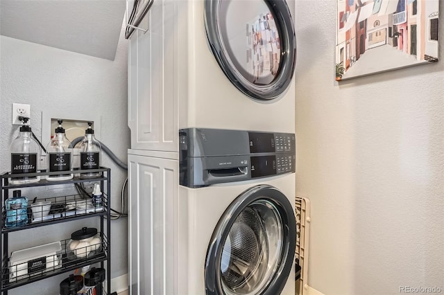 washroom featuring laundry area, stacked washer / drying machine, and a textured wall