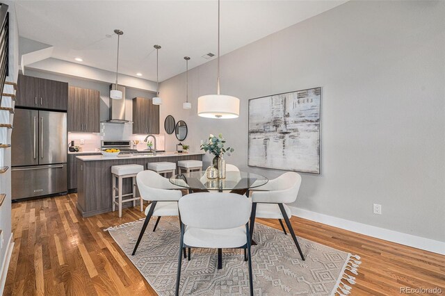 dining space with recessed lighting, wood finished floors, and baseboards