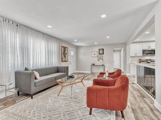 living room with a textured ceiling and light hardwood / wood-style floors