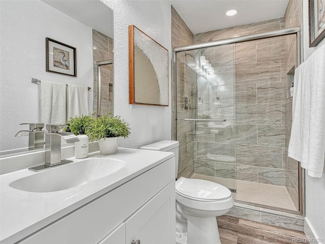 bathroom featuring vanity, an enclosed shower, and toilet