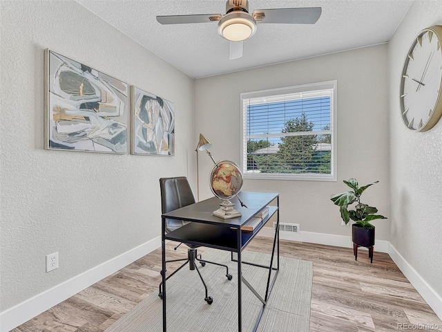 office area with a textured ceiling, light hardwood / wood-style flooring, and ceiling fan