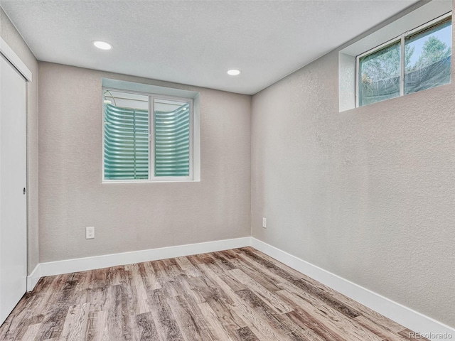 spare room with wood-type flooring and a textured ceiling