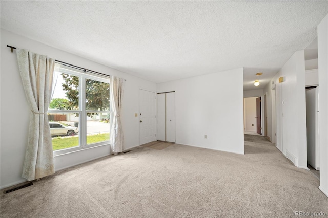 10007 Bryant St, Denver, CO 80260 - unfurnished living room featuring light colored carpet, plenty of natural light, and a textured ceiling