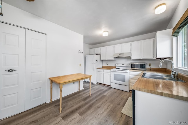10007 Bryant St, Denver, CO 80260 - kitchen with white appliances, under cabinet range hood, a sink, butcher block counters, and white cabinets