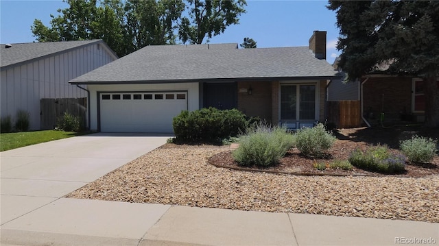 12256 E Bates Cir, Aurora, CO 80014 - view of front of house with an attached garage, concrete driveway, roof with shingles, and a chimney