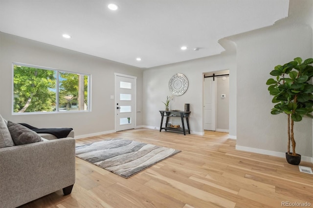 living area featuring light wood-type flooring and a barn door