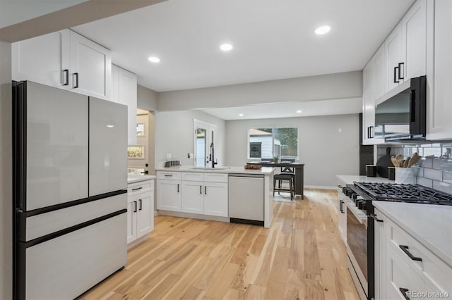 kitchen featuring light hardwood / wood-style flooring, stainless steel appliances, sink, and white cabinetry