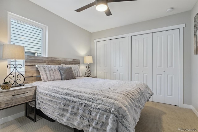 bedroom with two closets, ceiling fan, and light carpet