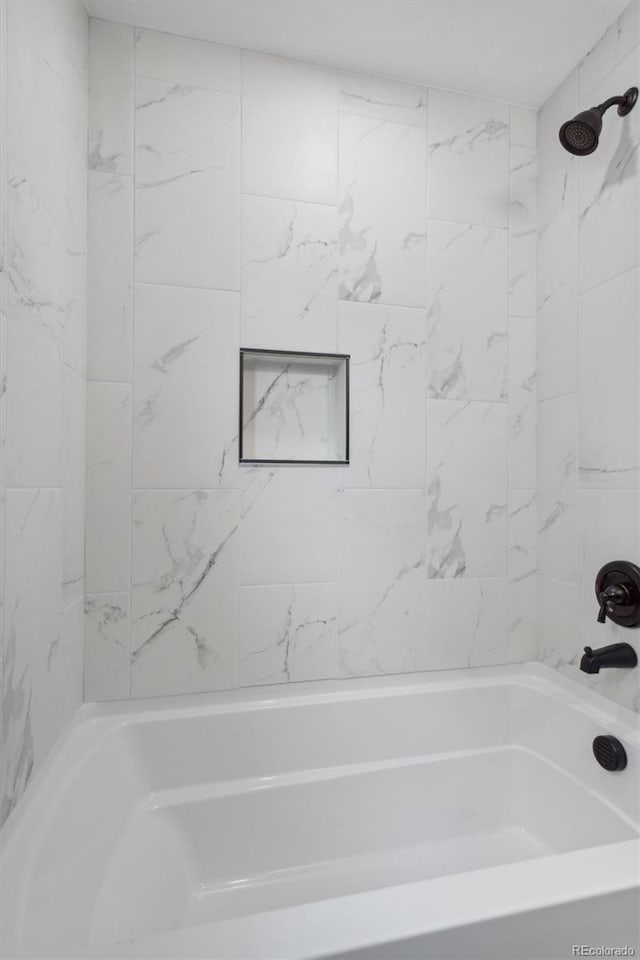 bathroom featuring tiled shower / bath