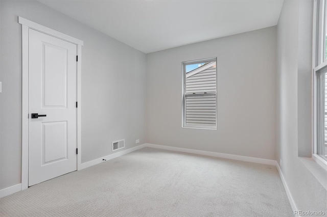 unfurnished room featuring light carpet