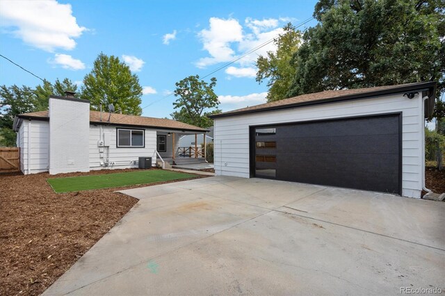 ranch-style house with a garage and central AC unit