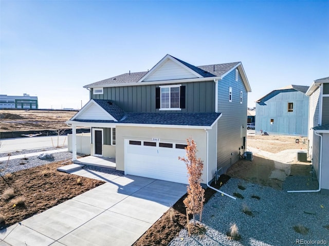 3889 N Shawee St, Aurora, CO 80019 - view of front of home with board and batten siding, concrete driveway, a garage, and roof with shingles