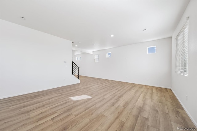 3889 N Shawee St, Aurora, CO 80019 - unfurnished living room with light wood-style floors, stairway, plenty of natural light, recessed lighting, and baseboards