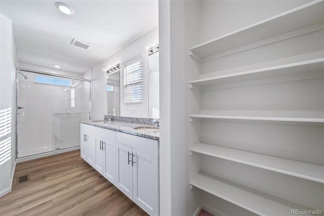 3889 N Shawee St, Aurora, CO 80019 - full bath featuring double vanity, a stall shower, wood finished floors, and recessed lighting