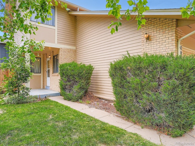 4032 S Atchison Way, Aurora, CO 80014 - property entrance featuring brick siding and a yard