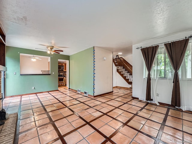 4032 S Atchison Way, Aurora, CO 80014 - unfurnished living room featuring a ceiling fan, stairway, light tile patterned floors, and a textured ceiling