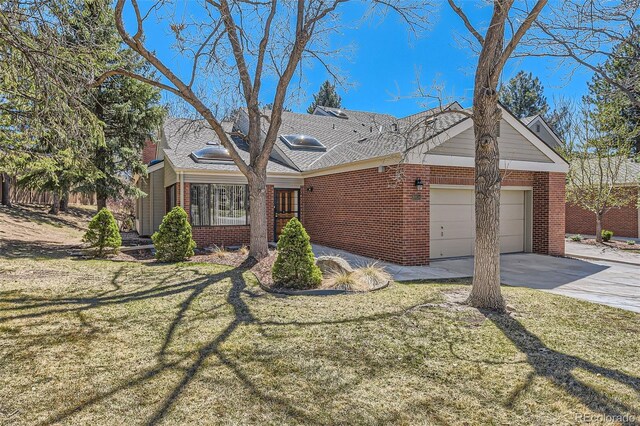 ranch-style home featuring driveway, a front yard, an attached garage, and brick siding