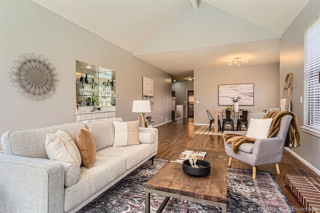 living room featuring baseboards, visible vents, high vaulted ceiling, and wood finished floors
