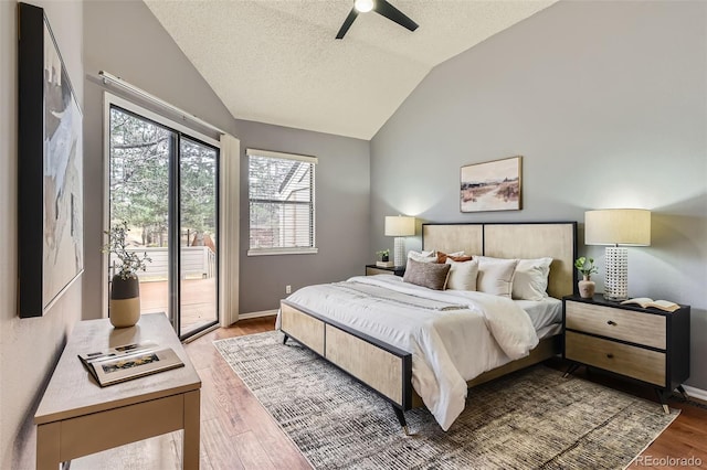 bedroom featuring light wood finished floors, baseboards, access to exterior, and lofted ceiling
