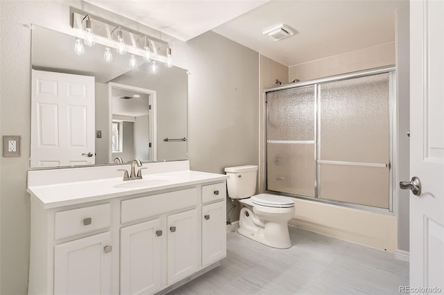 full bath featuring visible vents, toilet, bath / shower combo with glass door, and vanity