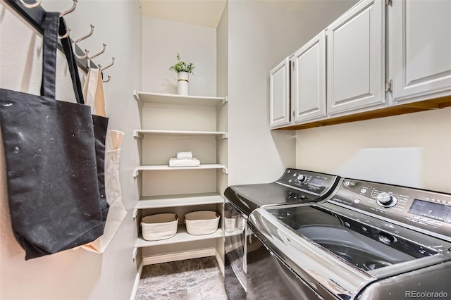 laundry area with baseboards, washing machine and clothes dryer, and cabinet space