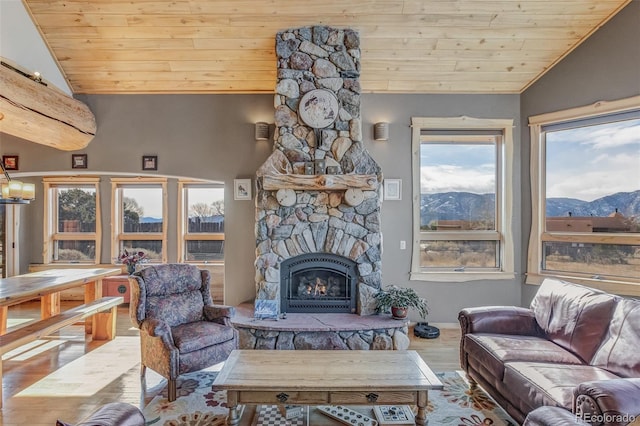 living room with lofted ceiling, wood ceiling, hardwood / wood-style flooring, a fireplace, and a mountain view