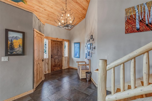 foyer entrance with wood ceiling, high vaulted ceiling, and a notable chandelier