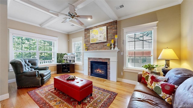 living room with coffered ceiling, a brick fireplace, hardwood / wood-style flooring, ceiling fan, and beamed ceiling