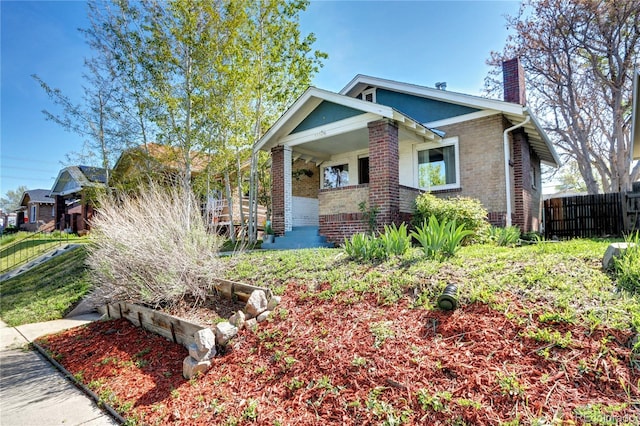 3336 N Saint Paul St, Denver, CO 80205 - view of front facade with brick siding, a chimney, fence, and a porch