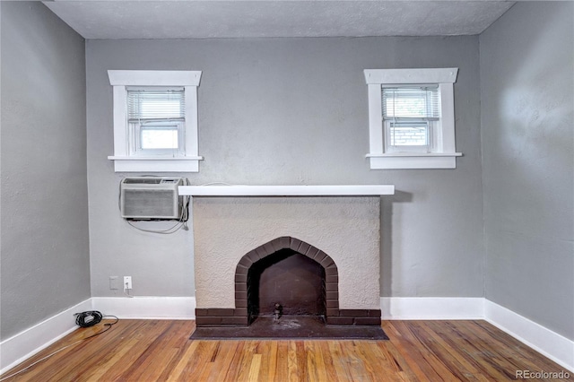 3336 N Saint Paul St, Denver, CO 80205 - unfurnished living room featuring healthy amount of natural light, baseboards, wood finished floors, and a wall mounted AC
