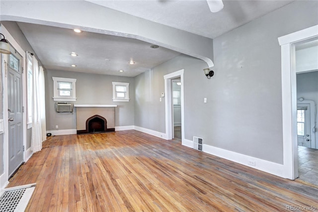 3336 N Saint Paul St, Denver, CO 80205 - unfurnished living room with light wood-style flooring, a fireplace with raised hearth, baseboards, recessed lighting, and cooling unit