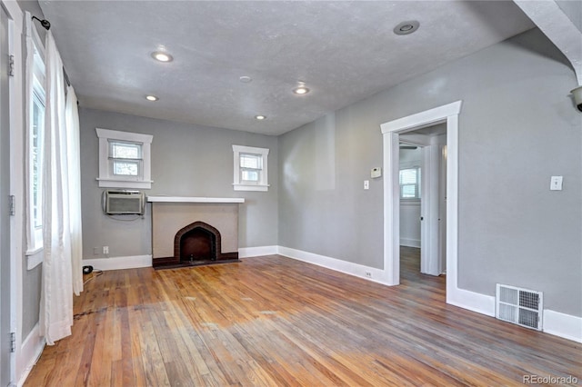 3336 N Saint Paul St, Denver, CO 80205 - unfurnished living room featuring a brick fireplace, wood-type flooring, plenty of natural light, and recessed lighting