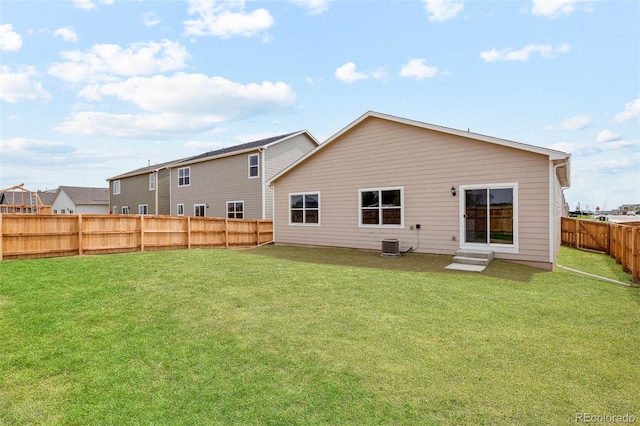 rear view of property featuring a lawn and central AC unit