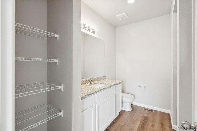 bathroom featuring hardwood / wood-style floors, vanity, and toilet