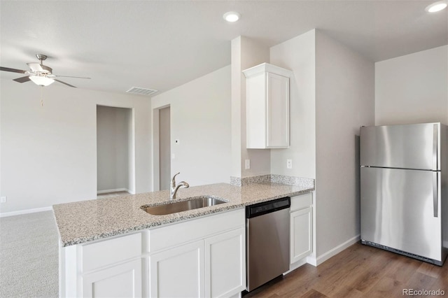 kitchen featuring white cabinetry, sink, ceiling fan, stainless steel appliances, and light stone counters