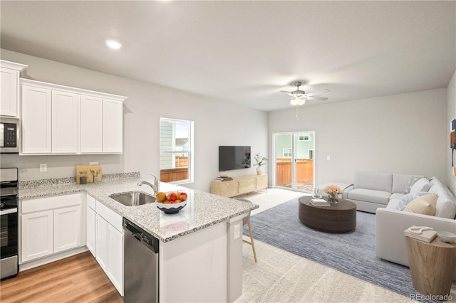 kitchen featuring kitchen peninsula, appliances with stainless steel finishes, white cabinetry, and sink