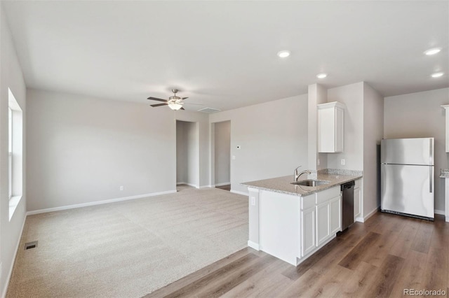 kitchen with ceiling fan, sink, stainless steel appliances, light stone counters, and white cabinets