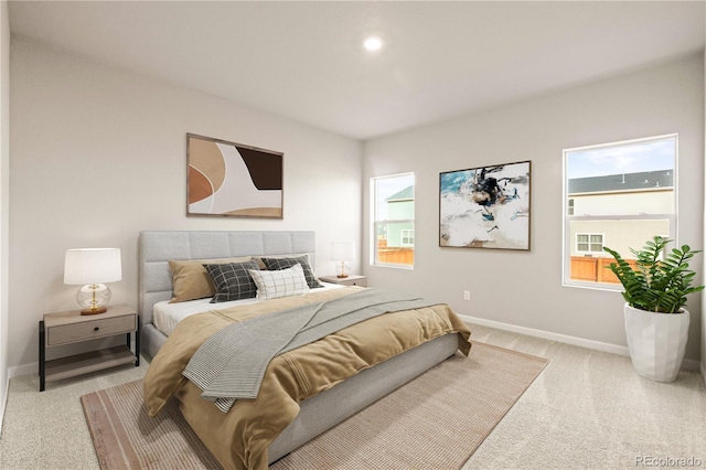 bedroom featuring multiple windows and light carpet