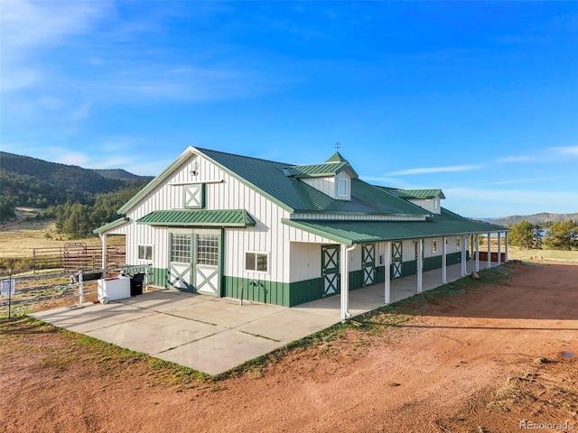 224 Lakeview Forest Hts, Florissant, CO 80816 - back of property featuring board and batten siding, a mountain view, a standing seam roof, and metal roof